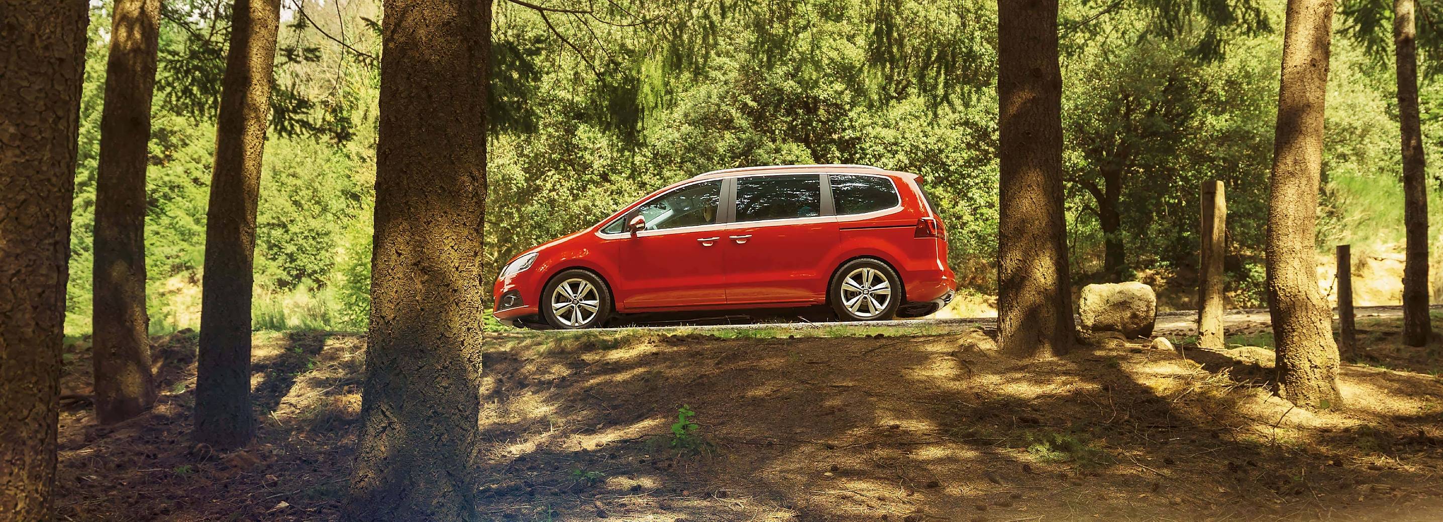 SEAT Alhambra familiar de 7 plazas en entorno boscoso rodeado de árboles.