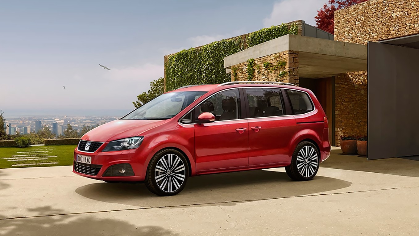 SEAT Alhambra monovolumen familiar de 7 en ciudad aparcado en el jardín de una vivienda.