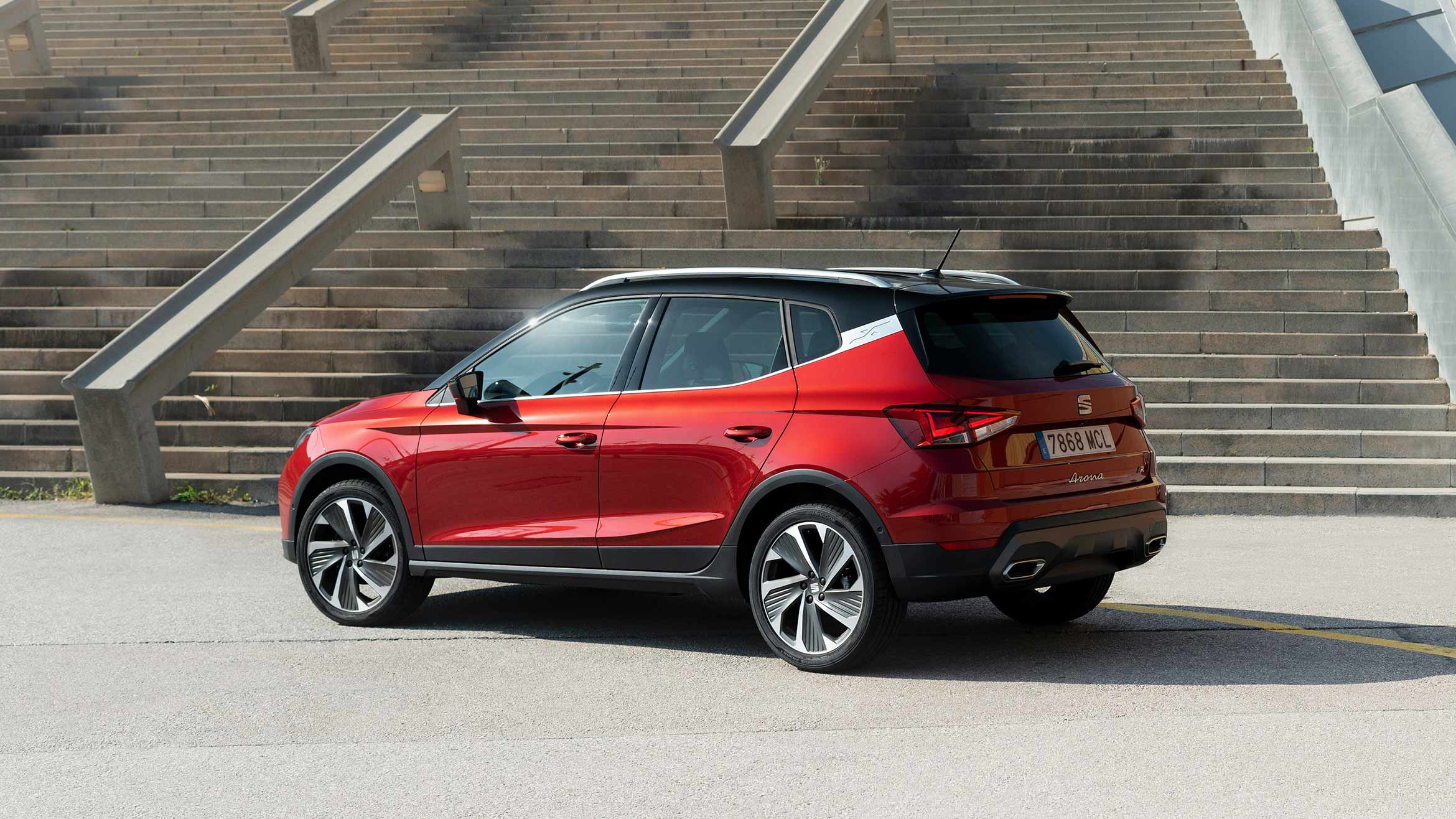 SEAT Arona FR SUV urbano en color rojo desire estacionado frente a escaleras