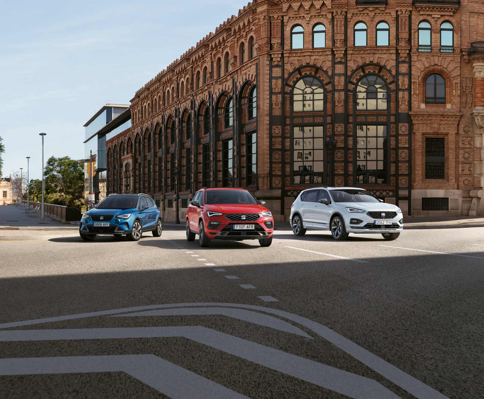 SEAT Arona dark camouflage al lado de un SEAT Ateca blanco bila y un SEAT Tarraco rojo merlot.