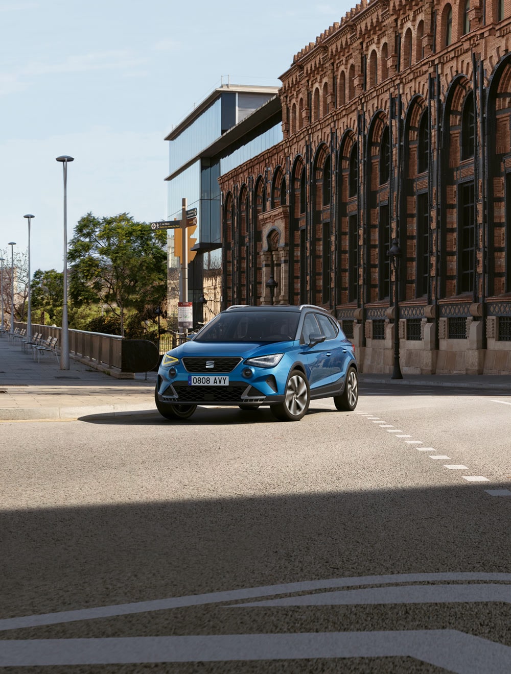 Mujer andando para poner una planta dentro del SEAT Arona dark camouflage con techo candy white.