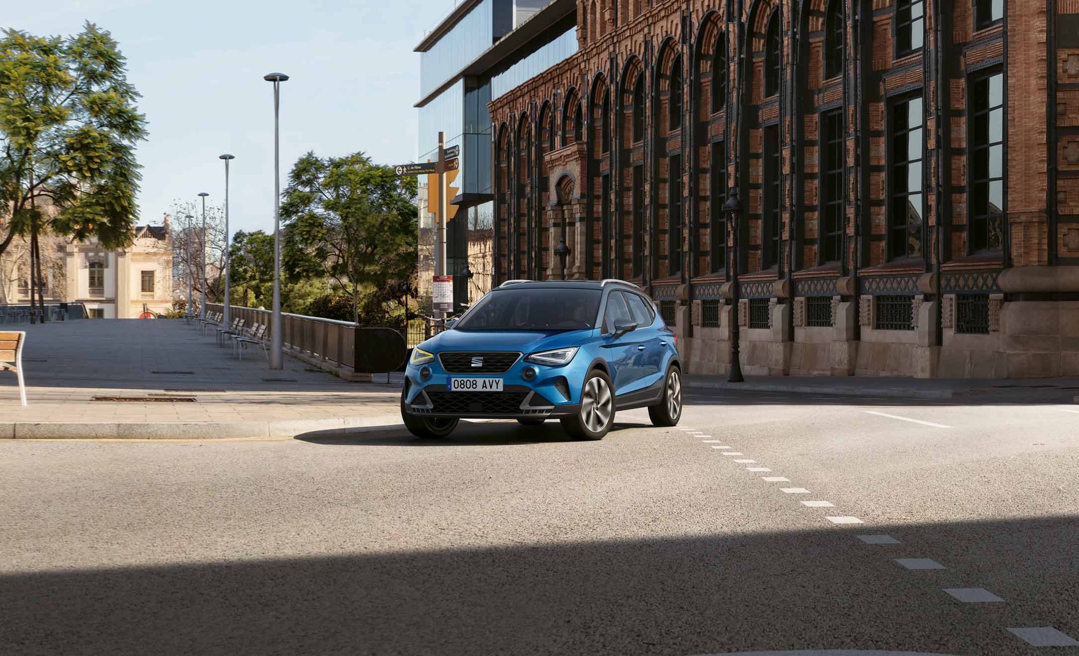 Mujer andando para poner una planta dentro del SEAT Arona dark camouflage con techo candy white.