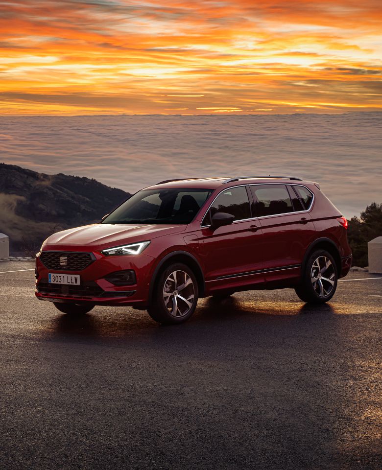 SEAT Tarraco SUV 7 plazas en colores rojo y negro aparcados en mirador al atardecer