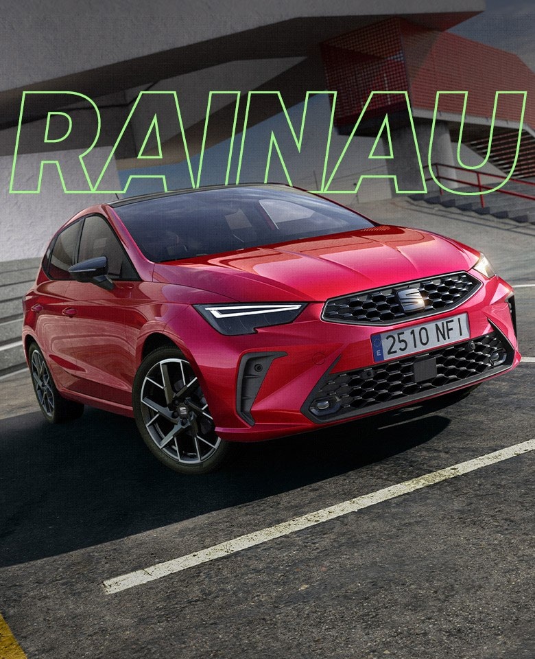 SEAT Ibiza FR compacto urbano con entrega inmediata aparcado en un estacionamiento comercial frente a edificio con fachada roja.