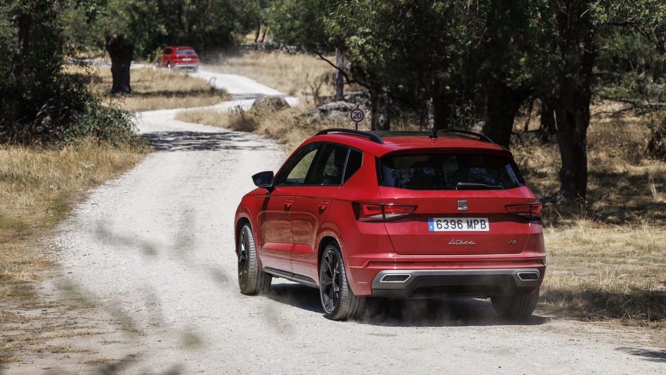 SEAT Ateca FR SUV familiar de color rojo velvet practicando offroad en camino boscoso