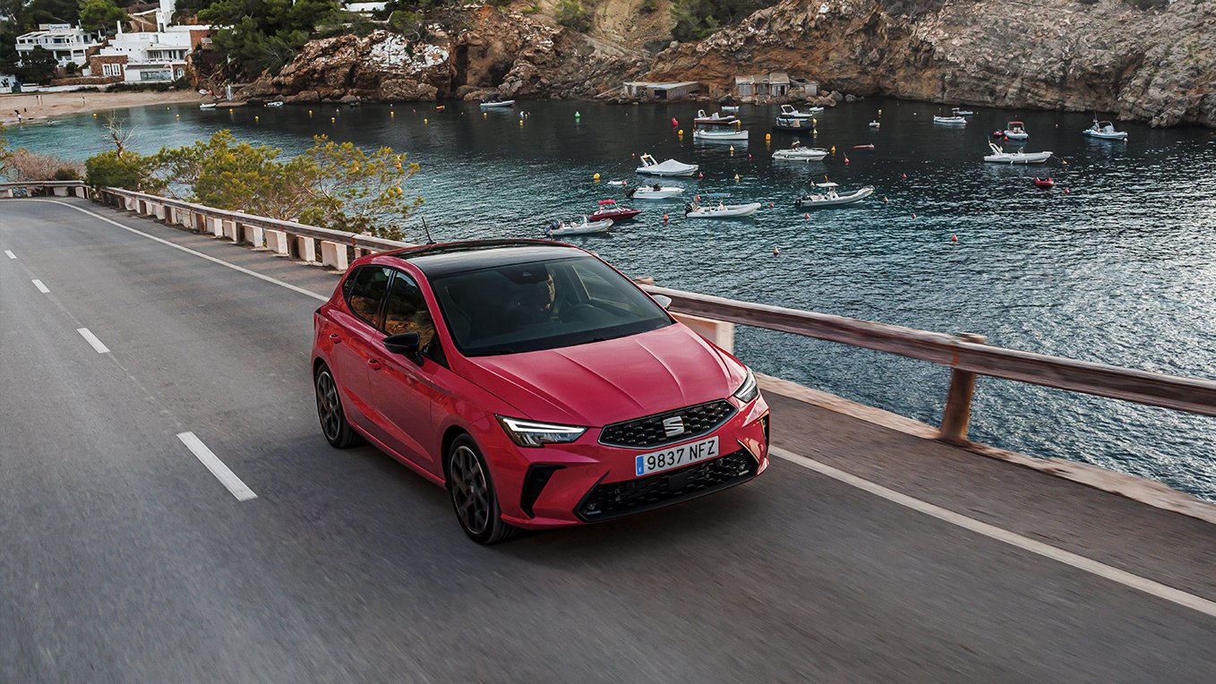 SEAT Ibiza FR compacto urbano de color rojo Liminal circula por una carretera costera junto a puerto deportivo