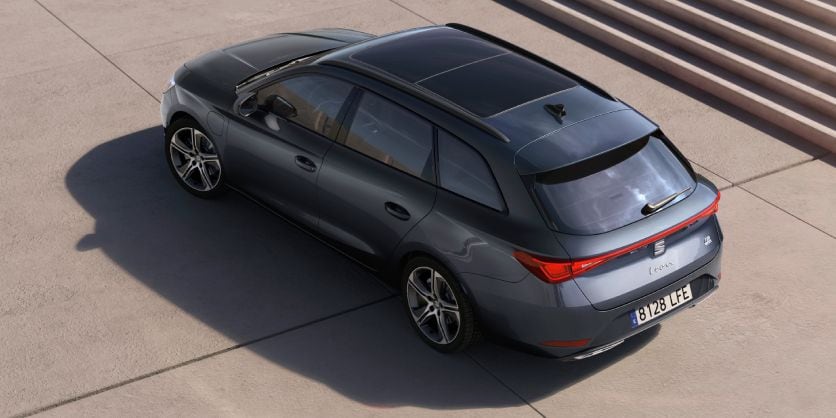 Vista cenital de un SEAT León Sporstourer en gris magnetic conectado a estación en aparcamiento público junto a escaleras