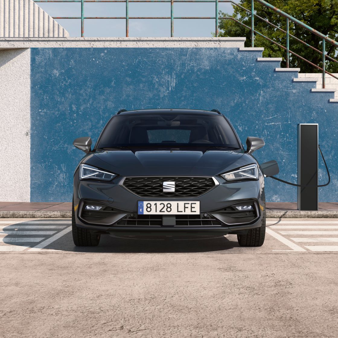Imagen frontal de un SEAT León vehículo eléctrico híbrido enchufable aparcado en una estación de carga bidireccional