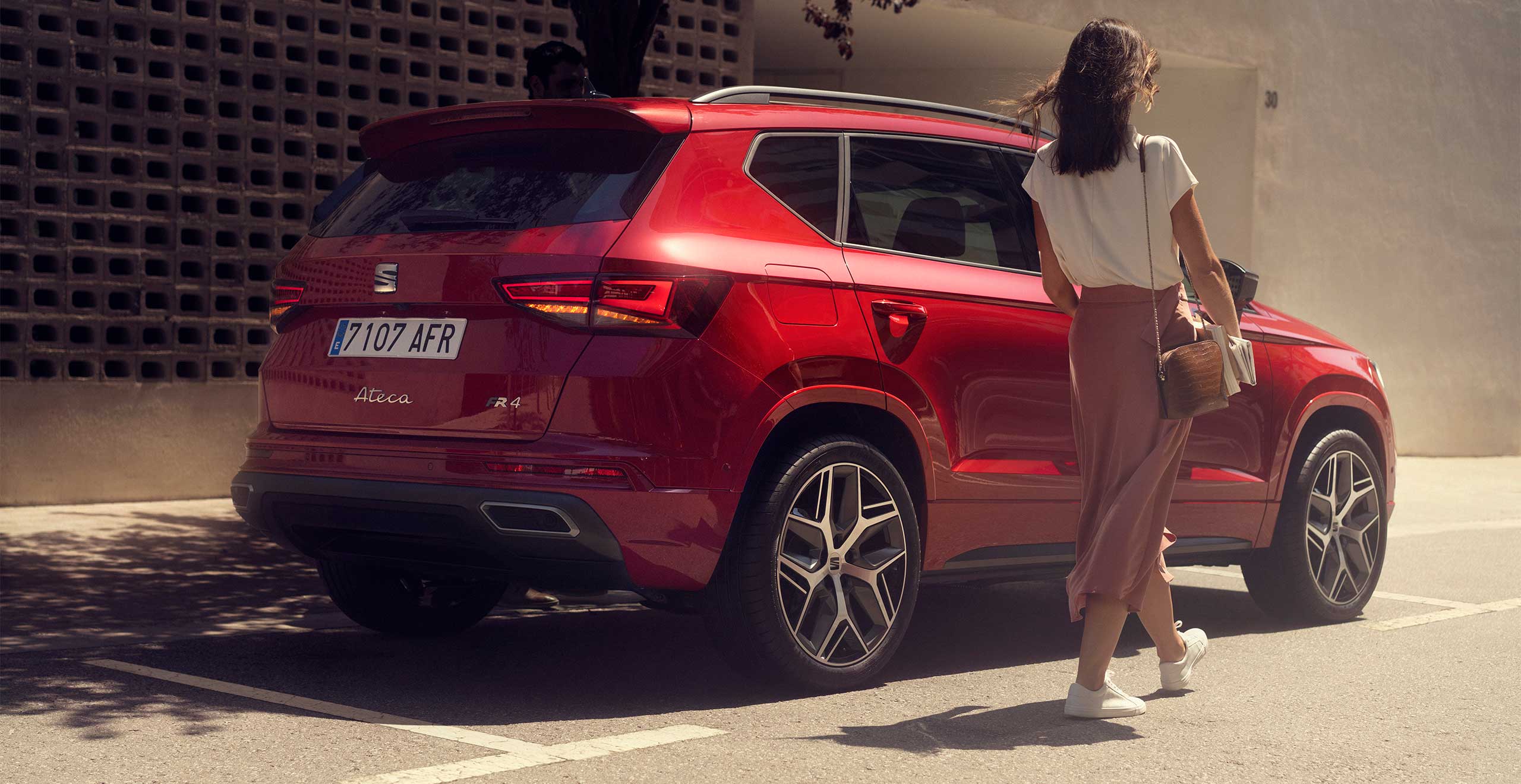 Vista trasera lateral del SEAT Ateca con un hombre sujetando el portón del maletero