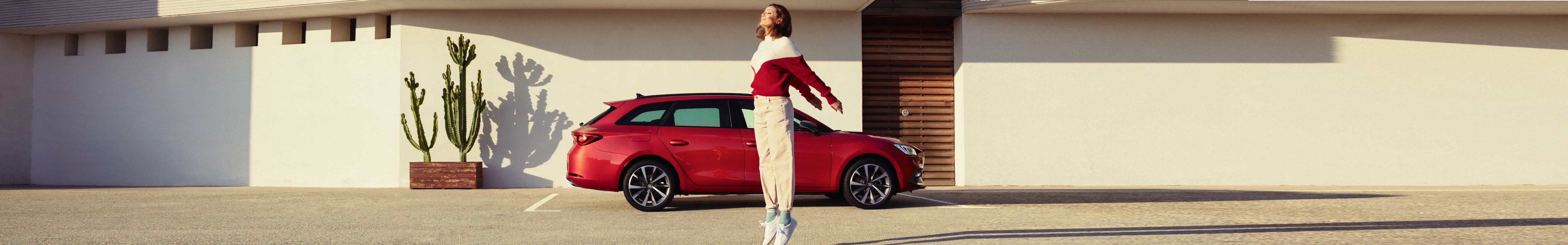 Pareja hablando junto a un SEAT León Xperience