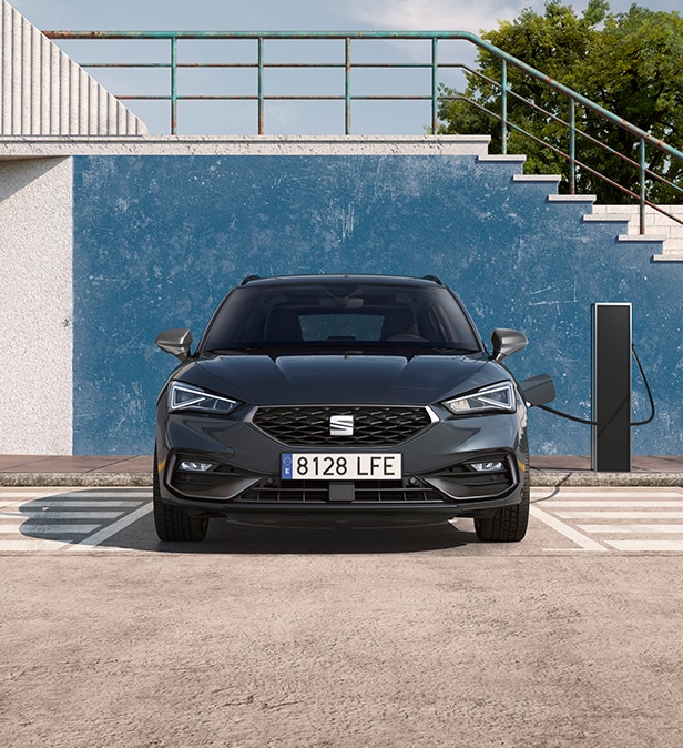 SEAT León vehículo eléctrico híbrido enchufable aparcado en una estación de carga bidireccional, como ejemplo de las capacidades avanzadas de carga híbrida.