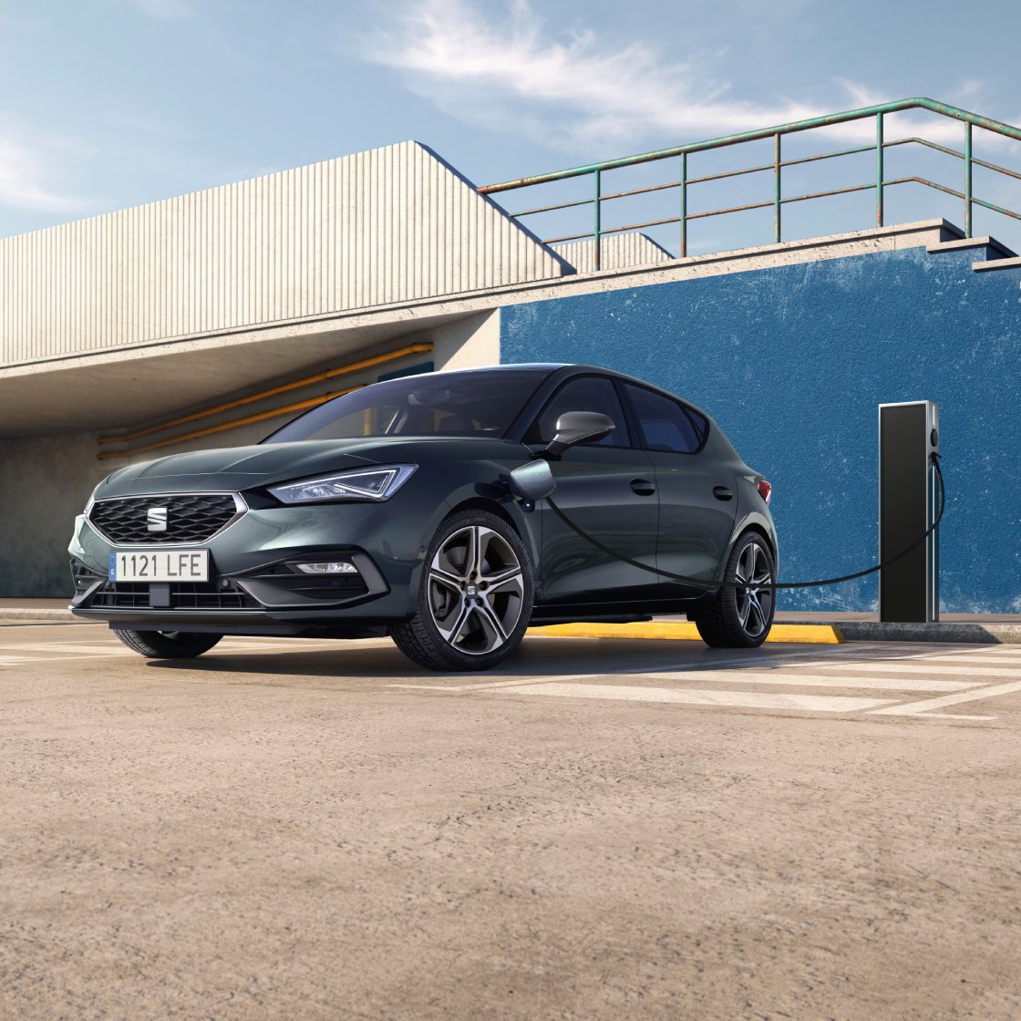 SEAT León compacto híbrido enchufable conectado a un poste de carga pública en un aparcamiento