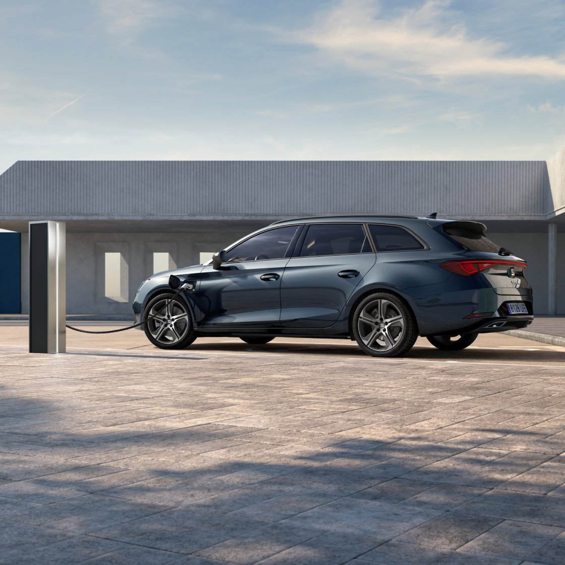 SEAT León Sportstourer familiar híbrido enchufable estacionado en aparcamiento público mientras carga su batería en poste de carga