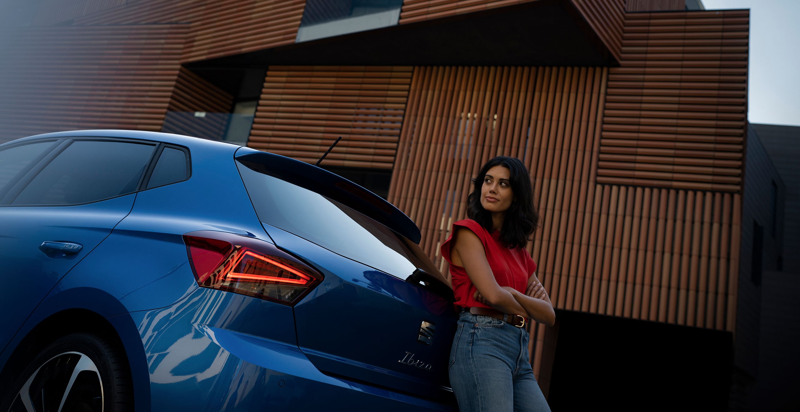 Mujer apoyada en parte trasera de SEAT Ibiza FR azul saphire