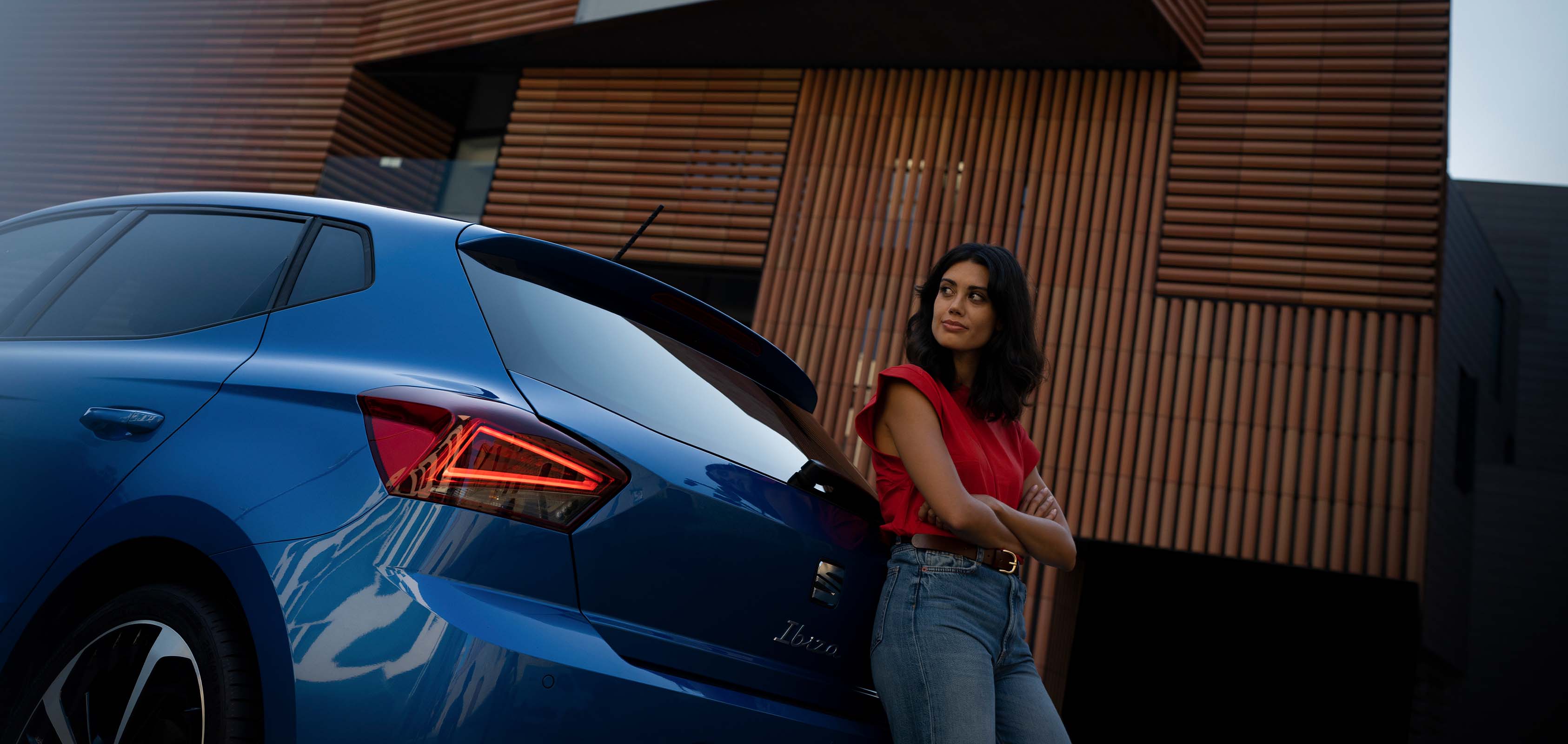 Mujer apoyada en parte trasera de SEAT Ibiza FR azul saphire
