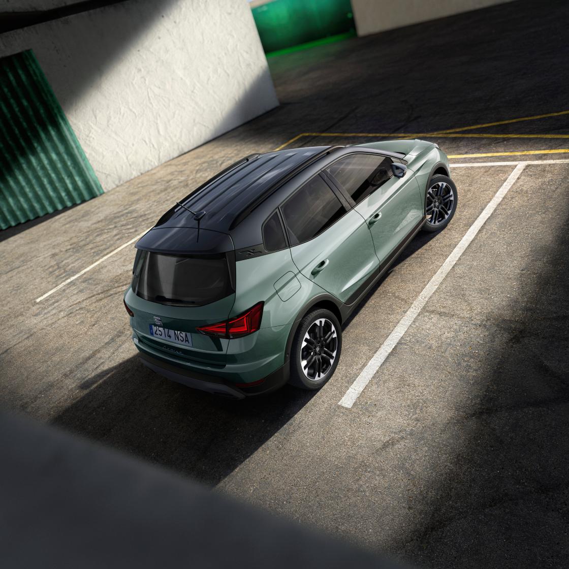 Vista picada trasera del Nuevo SEAT Arona, SUV urbano, en color oniric lake estacionado en aparcamiento público