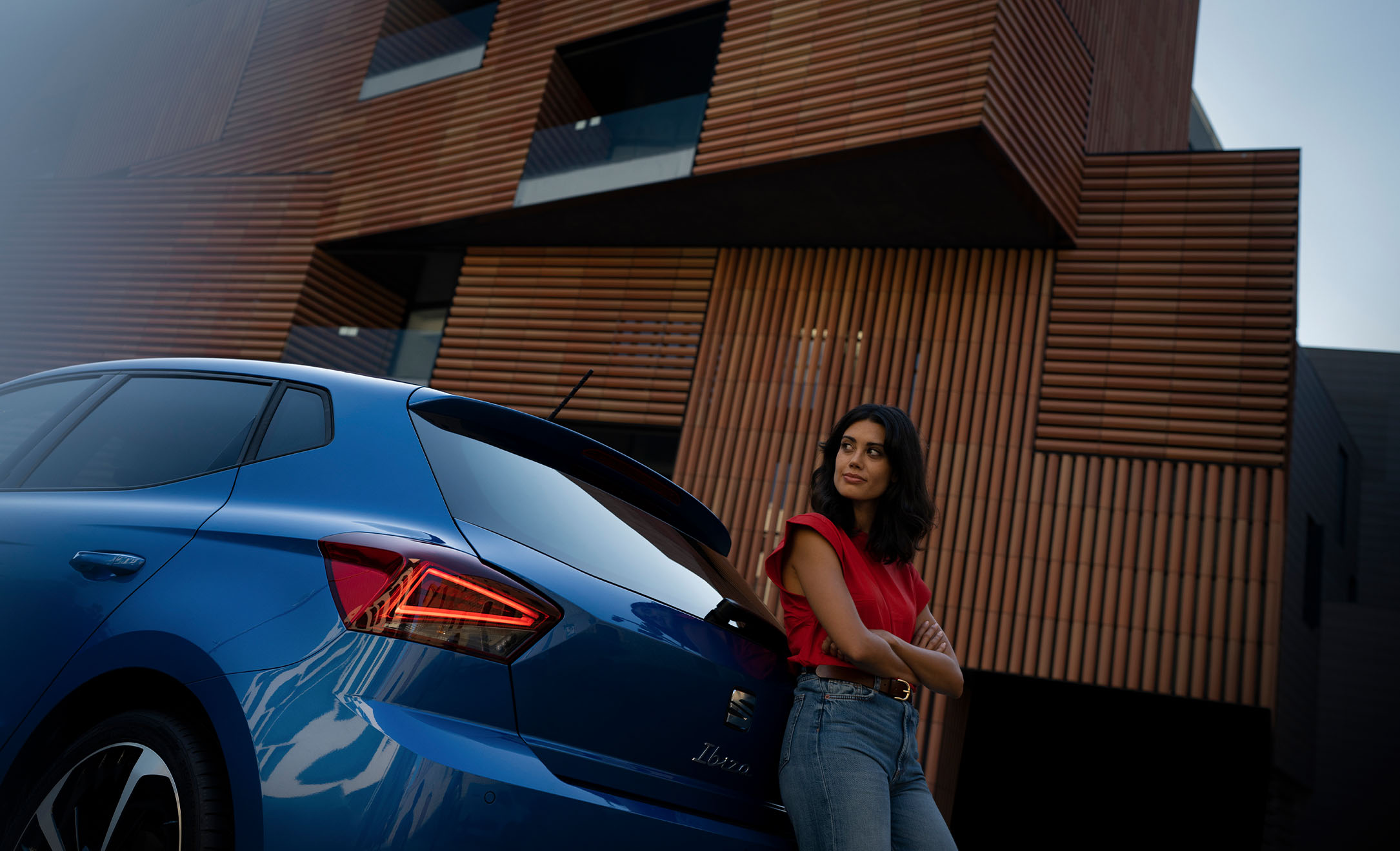 Mujer apoyada en parte trasera de SEAT Ibiza FR azul saphire