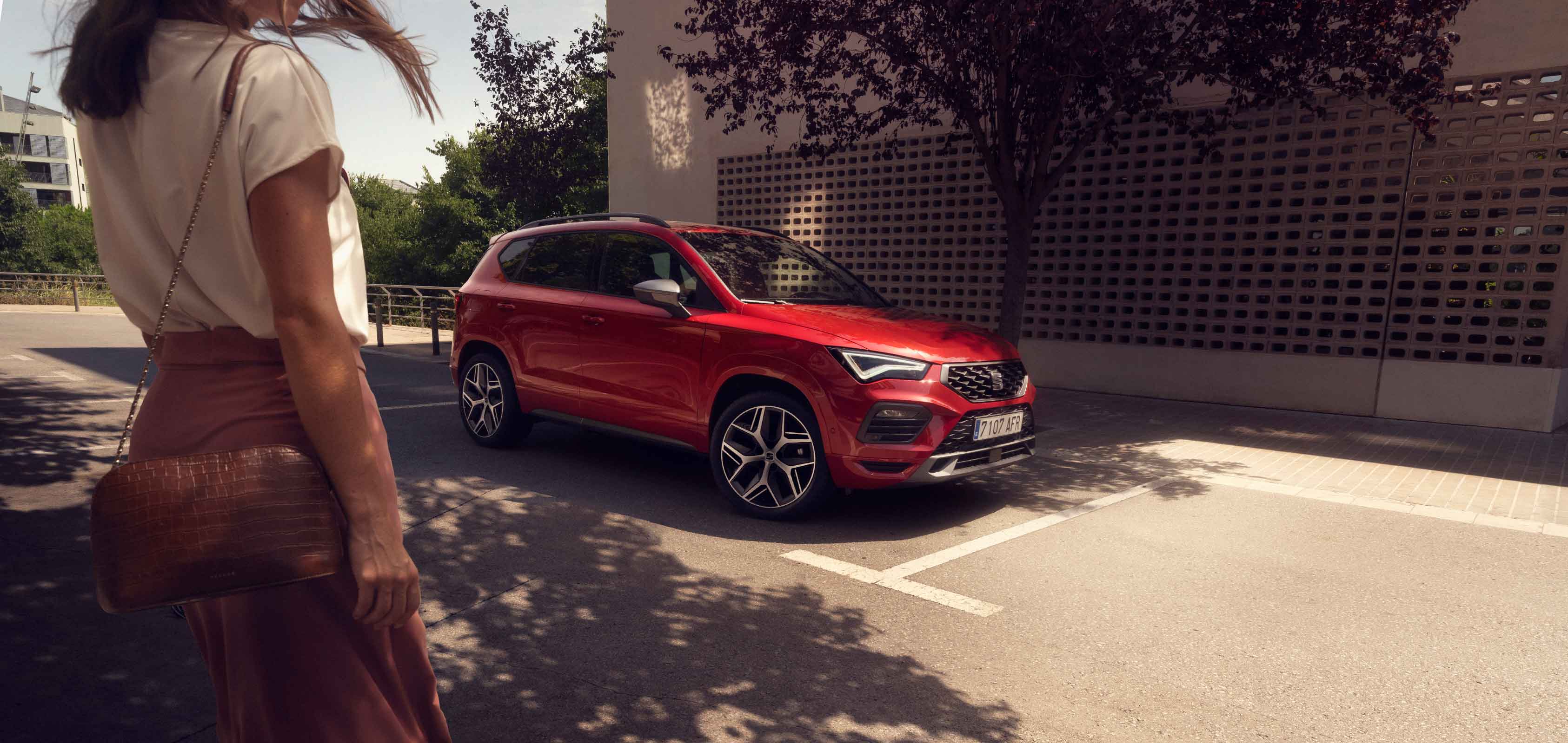 Mujer caminando hacia un SEAT Ateca color Rojo Velvet