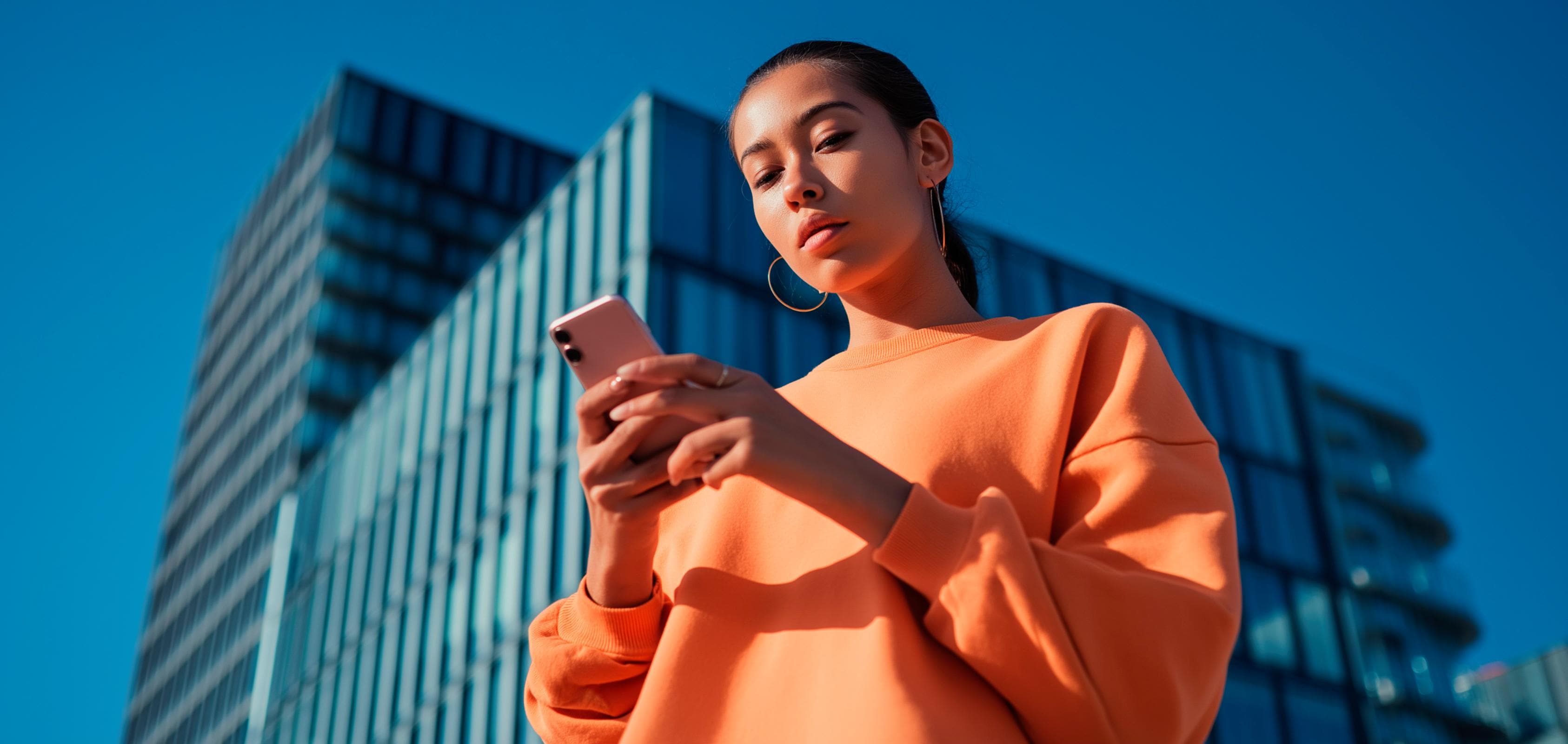 Mujer consulta la calculadora de mantenimiento de su SEAT en smartphone; fondo con edificio acristalado