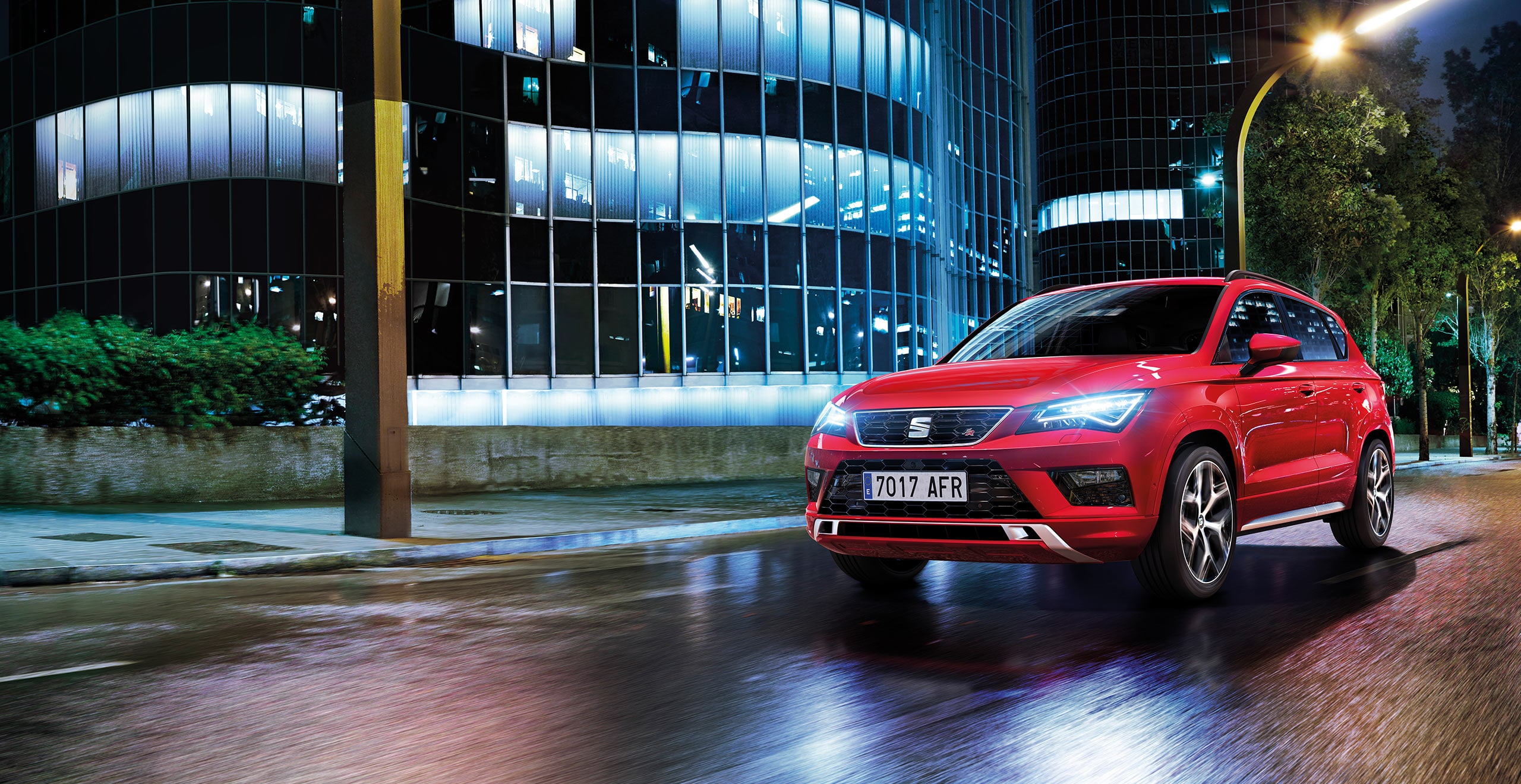 Vista frontal lateral del SEAT Ateca de noche en color rojo