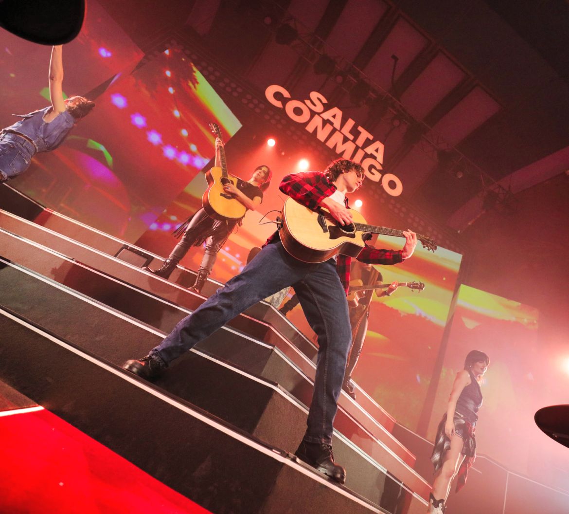 Artistas cantando y tocando la guitarra de una de las canciones en el musical Salta Conmigo de SEAT