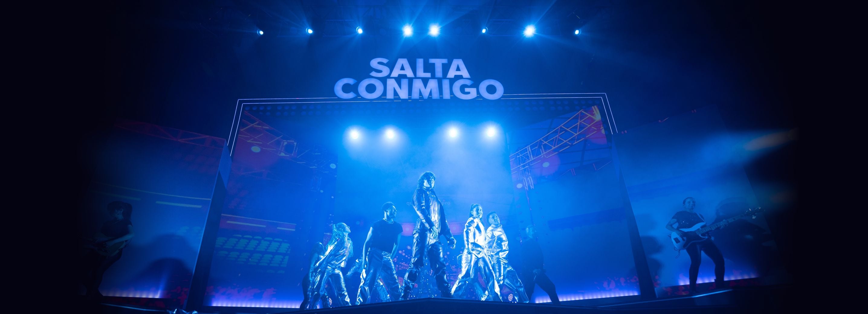 Músicos posan en el escenario iluminado con luces azules antes de empezar una de las canciones del musical de SEAT: Salta Conmigo