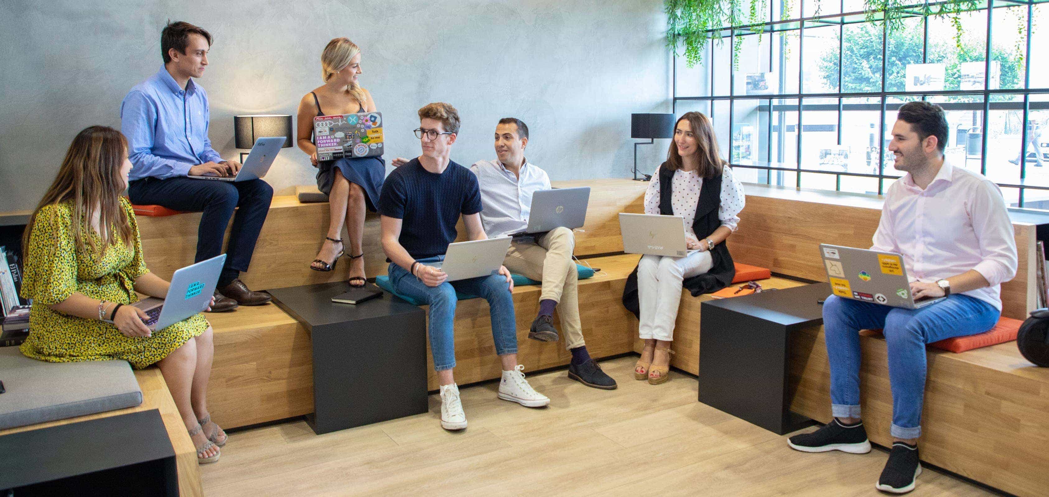 People gathered around a table with one man standing beside – SEAT Human Resources