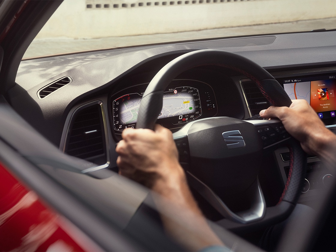 Vista interior del SEAT Ateca donde se ve el volante, para tener la tranquilidad de conducir seguro sabiendo que los Servicios de Movilidad de SEAT ofrecen asistencia en carretera.