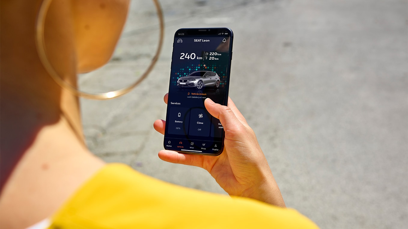 una persona con un smartphone, utilizando My SEAT app, una función de SEAT Connect que ofrece acceso y funciones a distancia del vehículo.