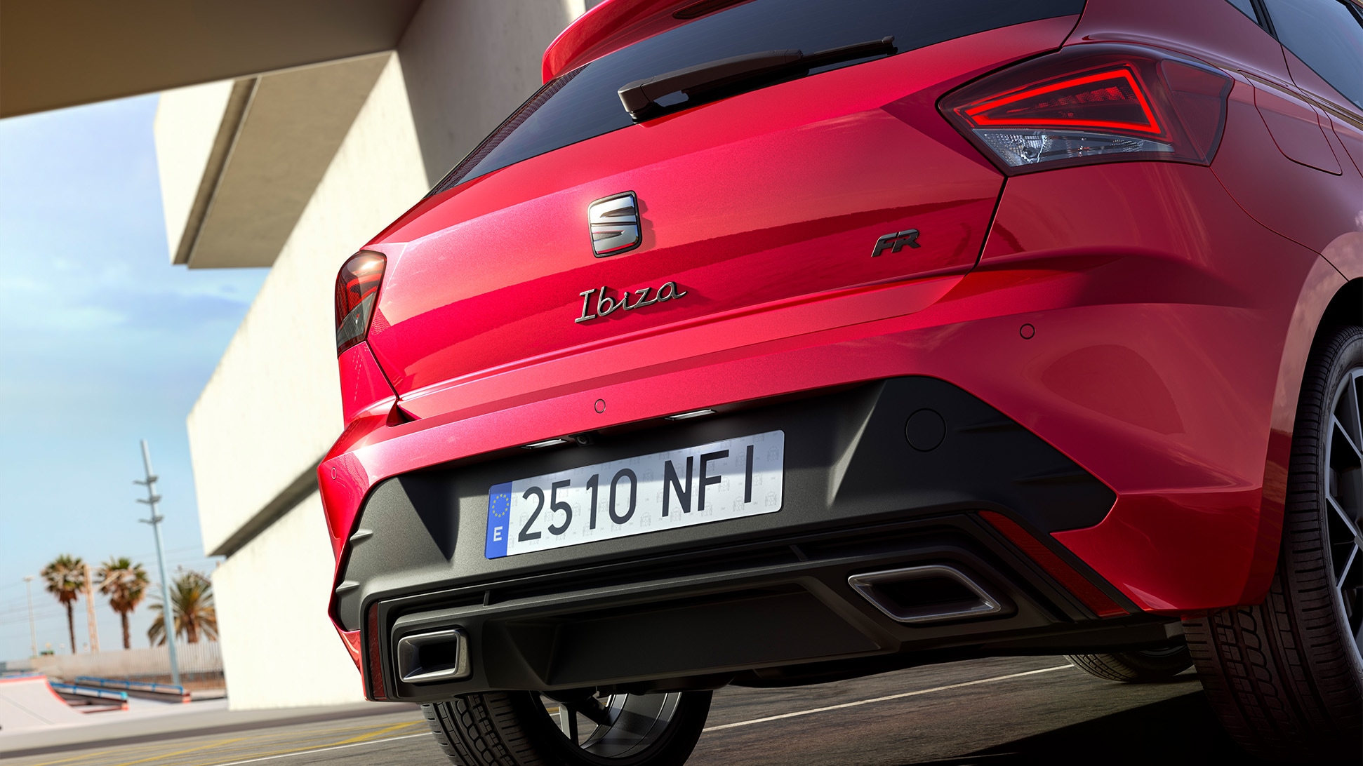 Vista trasera de un SEAT Ibiza de color rojo, aparcado al aire libre. 