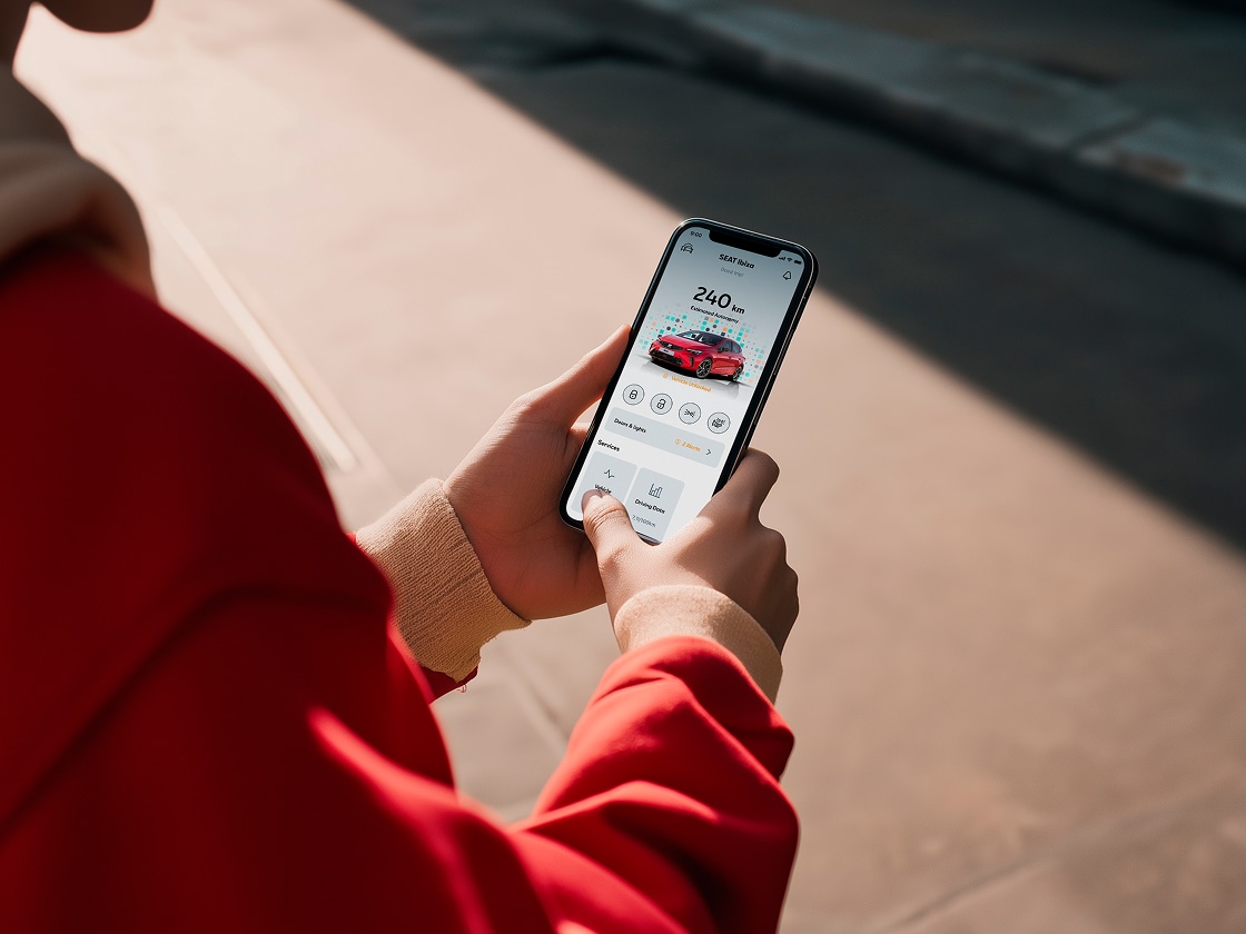 Persona con un smartphone utilizando las funciones remotas de seat Persona con un smartphone utilizando las funciones remotas de seat