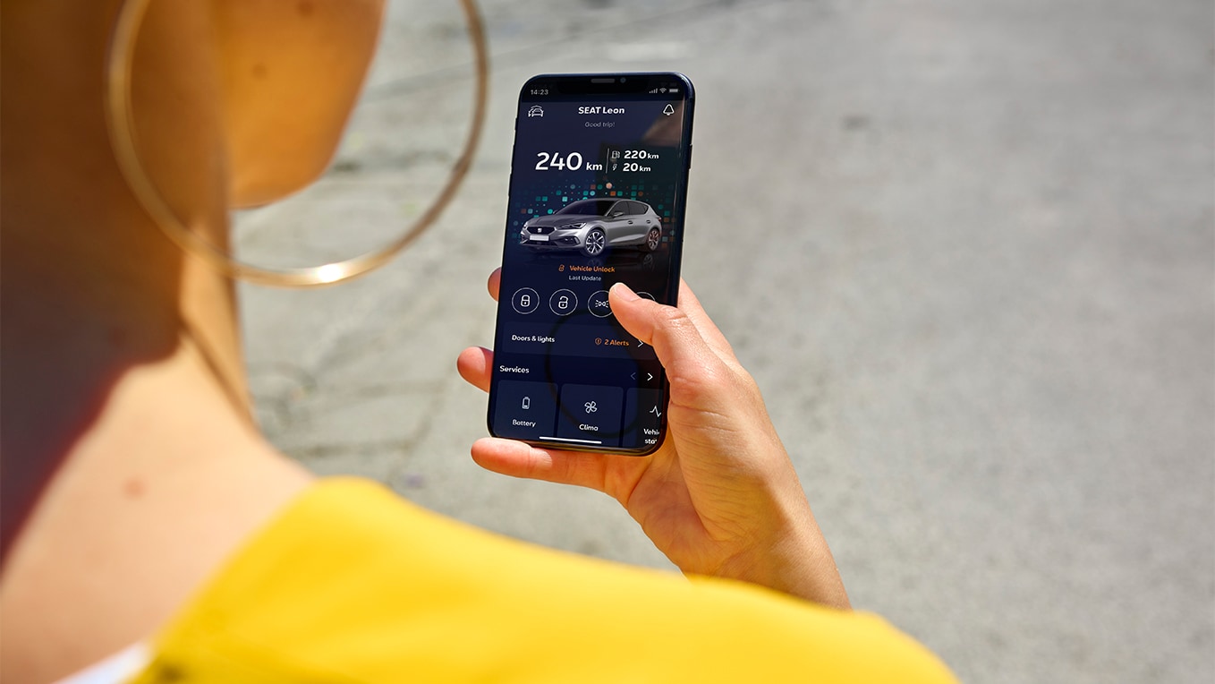 Una persona con un smartphone utilizando My SEAT app, una función de SEAT Connect, para acceder a distancia a las prestaciones del vehículo.