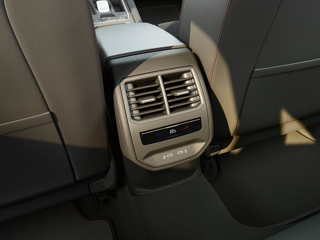 Vista interior trasera donde se ve el Comfort Pack del SEAT León Sportstourer con Climatronic de 3 zonas, tomas USB tipo C y reposabrazos central.