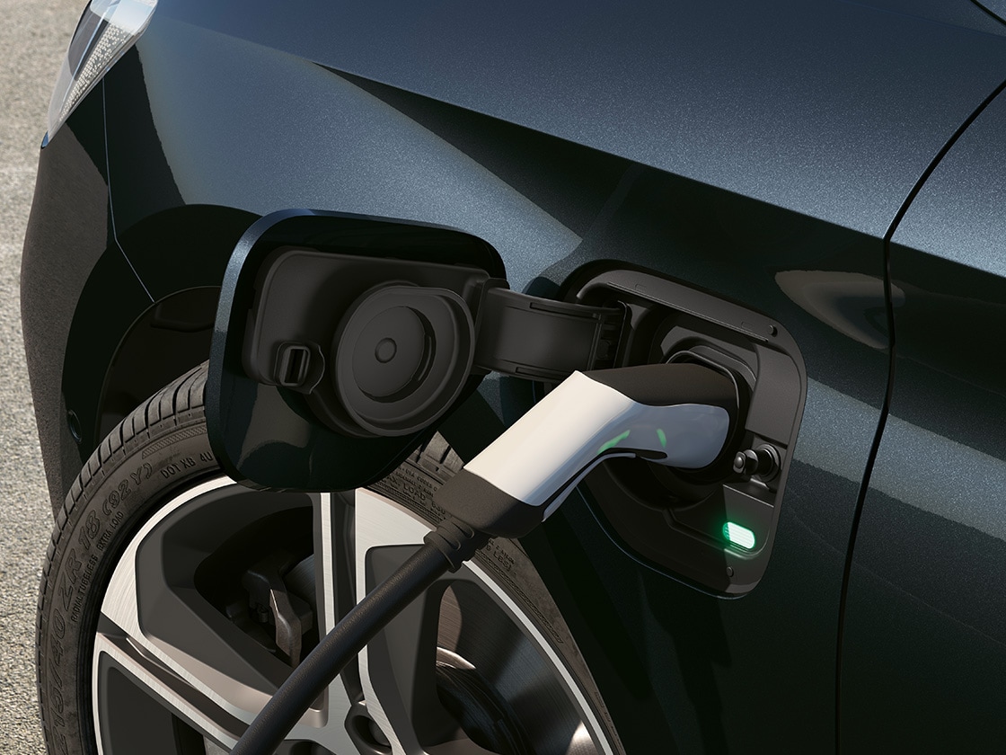 Puerto de carga del SEAT León Sportstourer 2025, prestación del coche híbrido enchufable que complementa el sistema de frenado regenerativo.