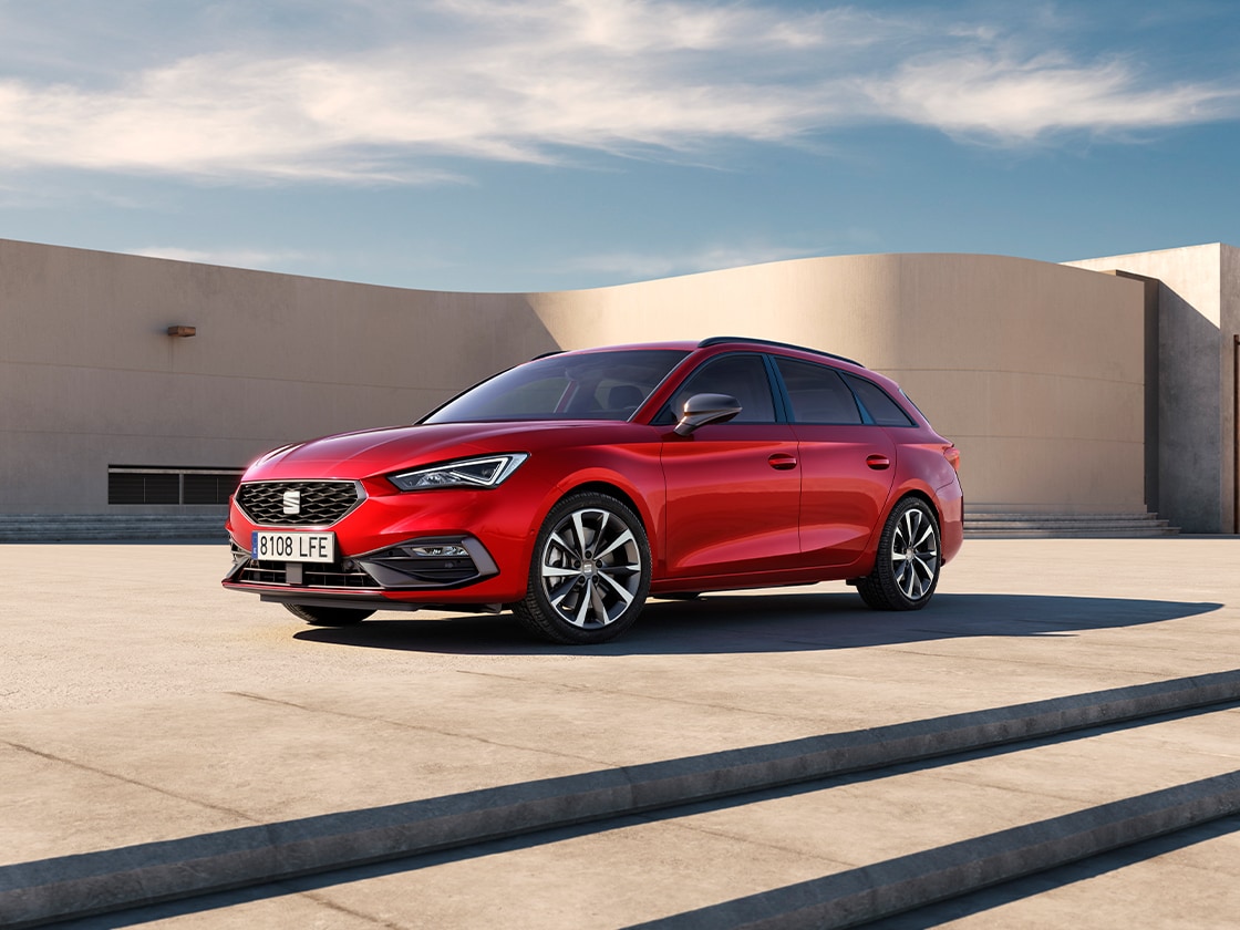 SEAT León Sportstourer FR con elegantes llantas de aleación y un atractivo perfil de conducción (Drive Profile). El vehículo más destacado de la gama SEAT delante de un fondo al aire libre.