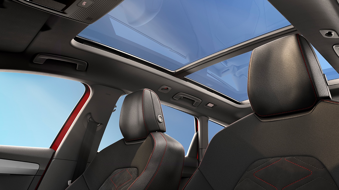 Vista interior del coche con asientos y techo solar panorámico.