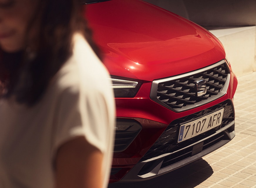 mujer-de-pie-junto-a-seat-ateca-color-rojo-velvet