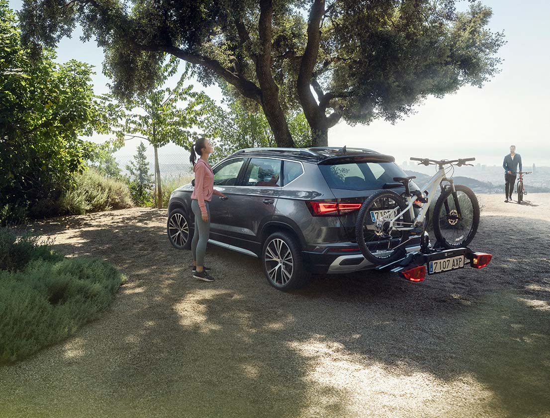 mujer-de-pie-junto-al-seat-ateca-con-un-accesorio-del-portabicicletas