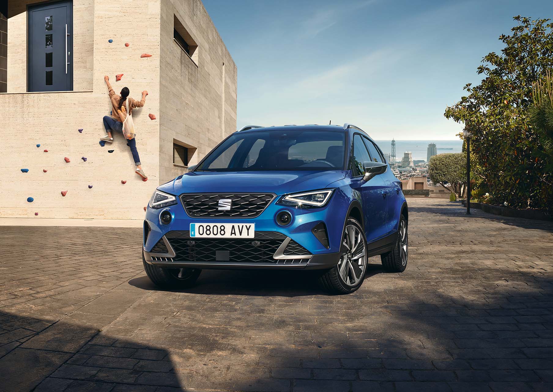 seat arona fr aparcado junto a niña escalando muro