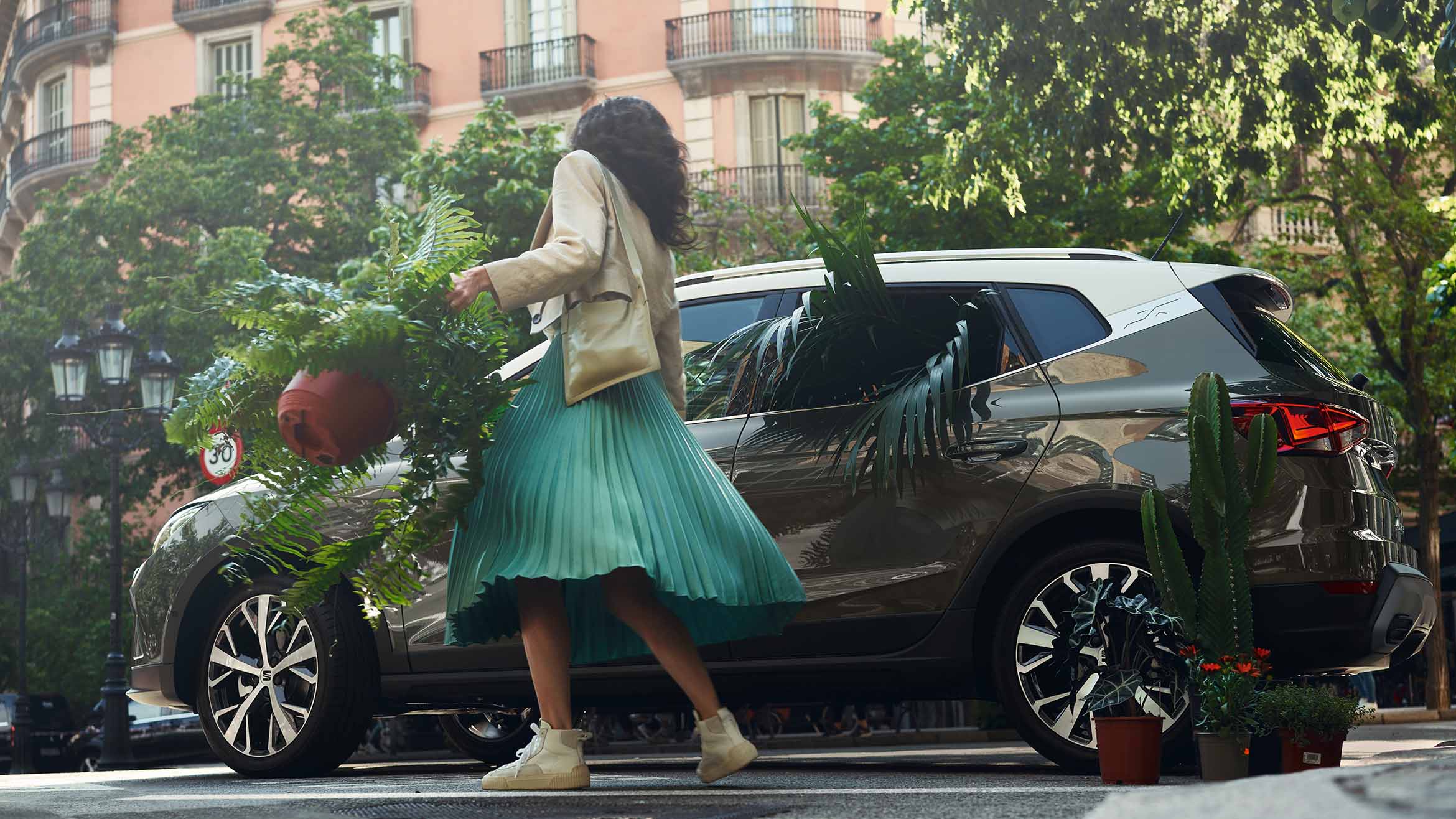 mujer-con-planta-abriendo-seat-arona-acantilado-puerta-gris