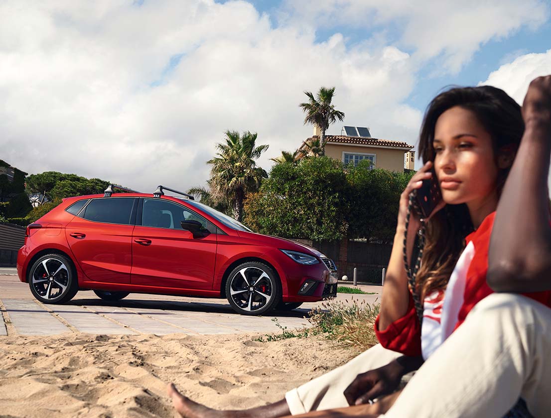 mujer-hablando-por-teléfono-con-seat-ibiza-de-fondo