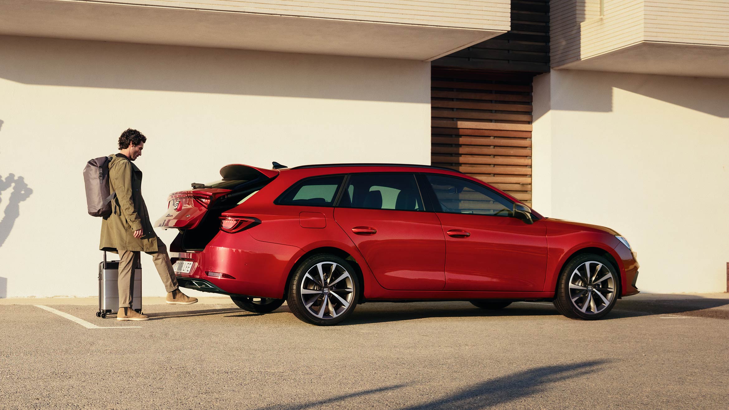 hombre abriendo el maletero del SEAT León color rojo Desire