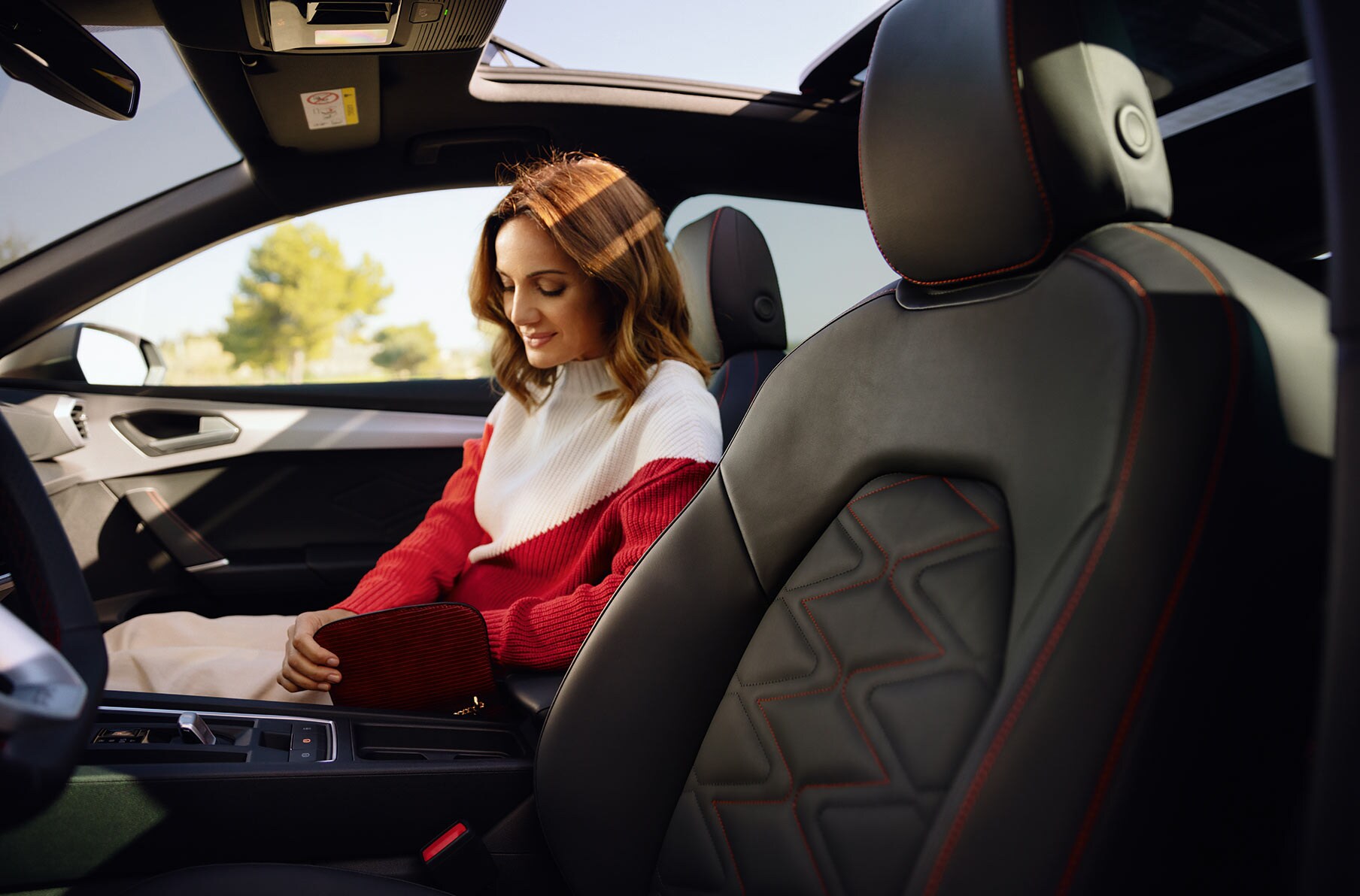 mujer sentada en el asiento del copiloto, disfrutando del interior del SEAT