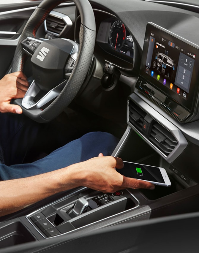 hombre cargando su smartphone con el cargador inalámbrico del SEAT León