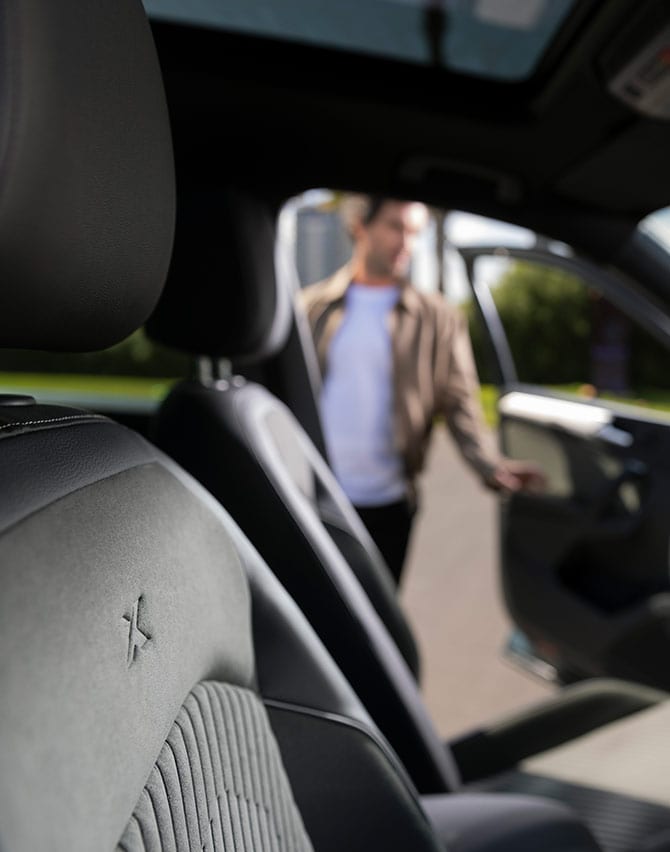 Persona caminando hacia el nuevo SEAT Tarraco XPERIENCE color Dark Camouflage mientras se carga