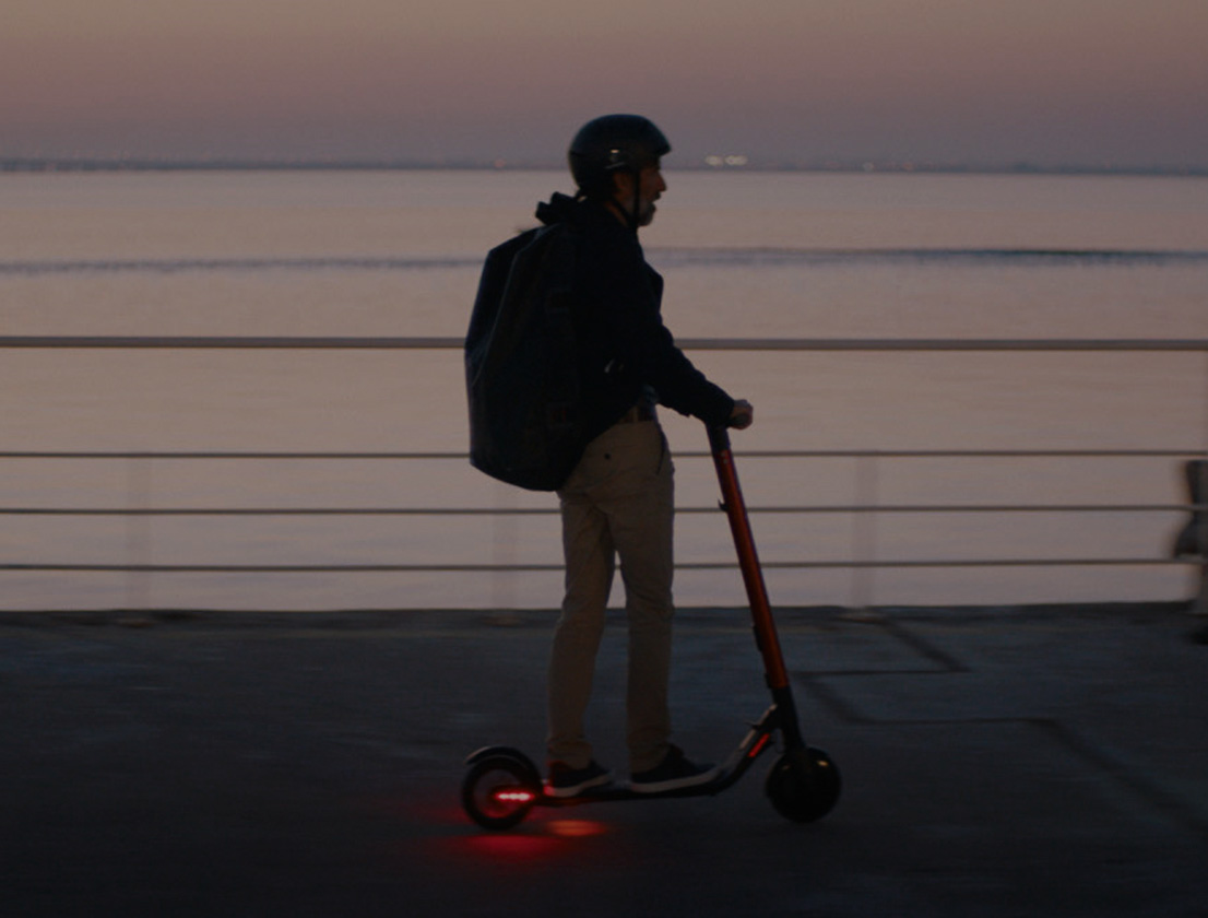 Persona conduciendo su patinete eléctrico SEAT MÓ 25 con luces LED de larga duración 