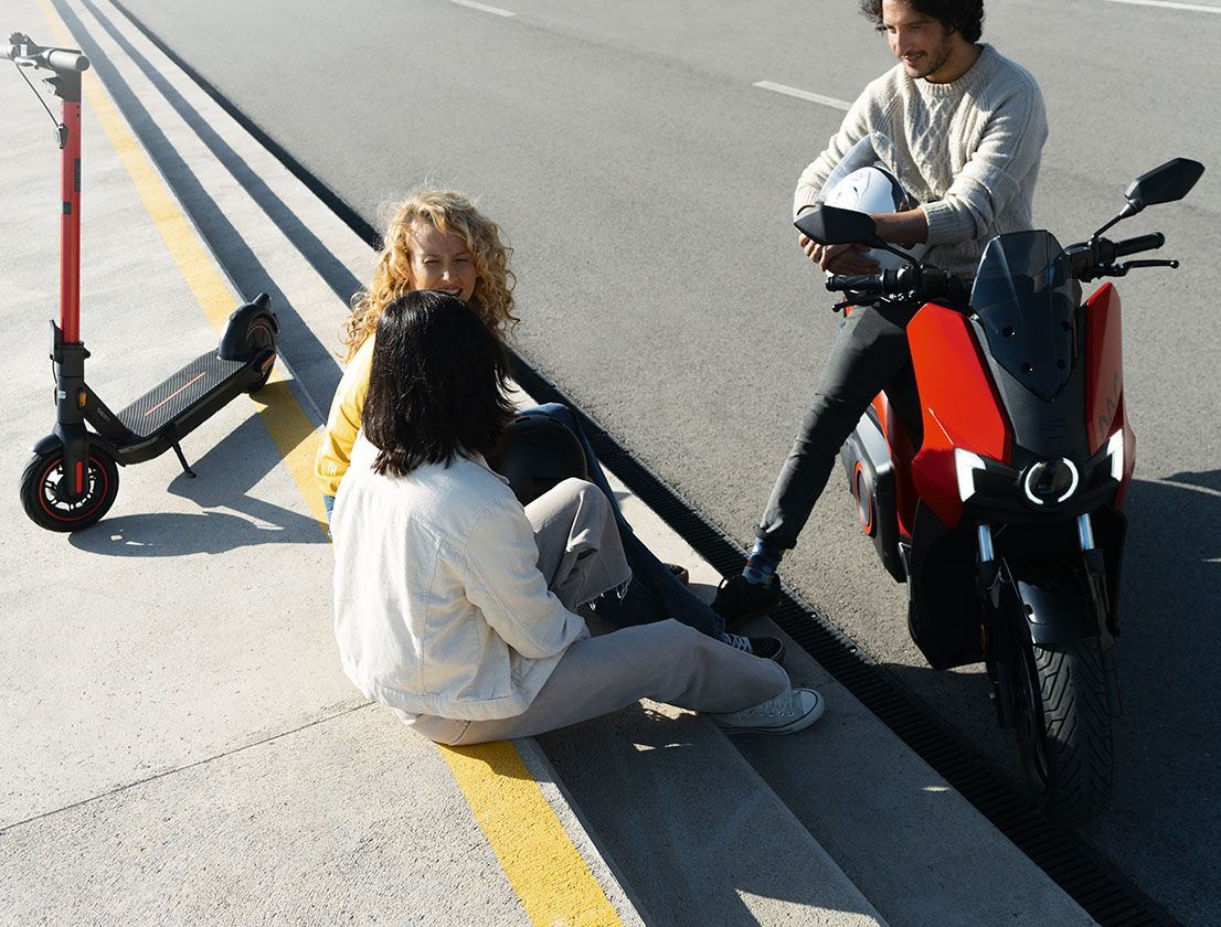 grupo de amigos sentados junto a sus scooters SEAT MÓ 125 y SEAT MÓ 65 eléctrico