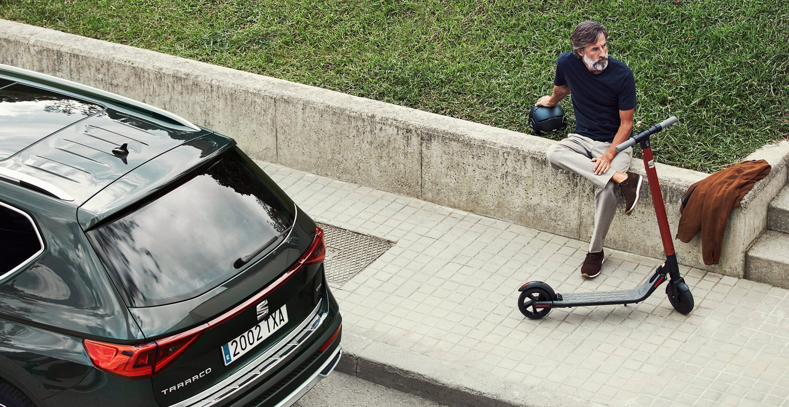 Hombre acompañado del patinete eléctrico de SEAT eXS Kickscooter