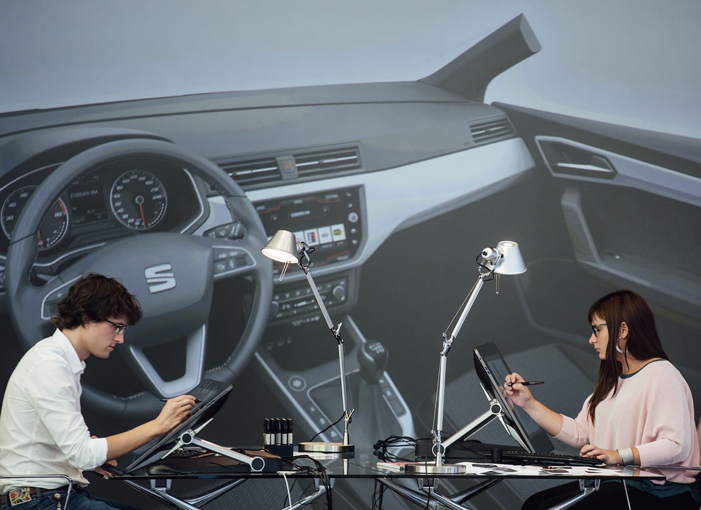 Dos diseñadores de coches dibujando sobre pantallas electrónicas
