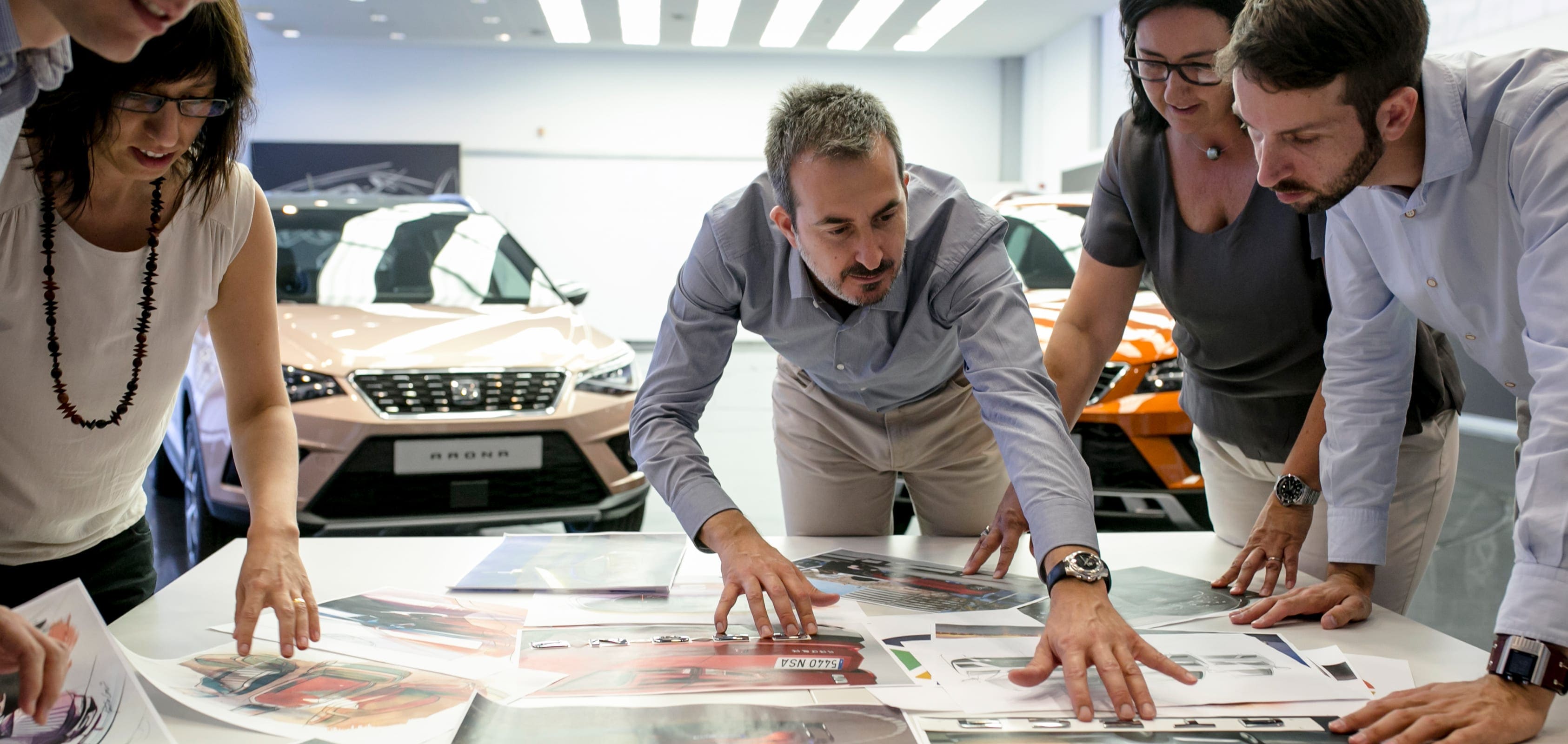 Trabajadores con varias fotografías de coches de SEAT